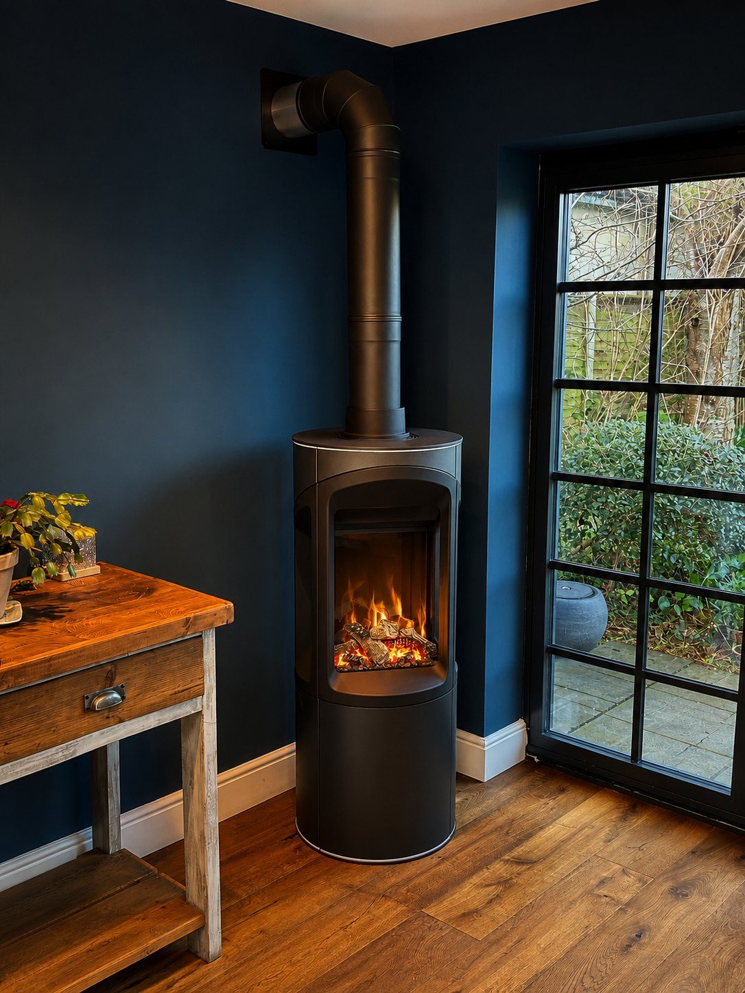 A wood-burning stove set into a contemporary alcove with log storage
